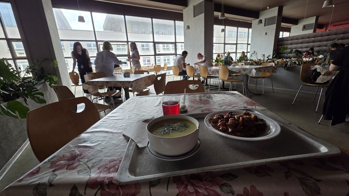 Stoliki przy panoramicznych oknach z miskami zup na blacie